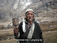 Old man with a tibetan prayer wheel in Langtang village